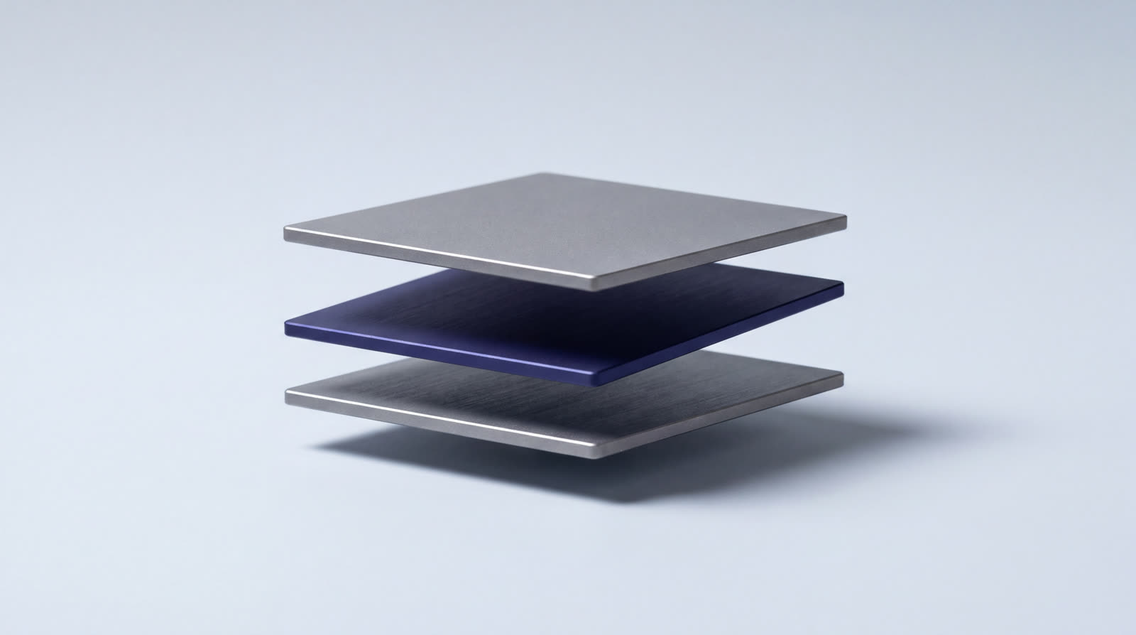 Three machined plates held apart in stepped layers, each with a visible milled edge and its own separate cast shadow.